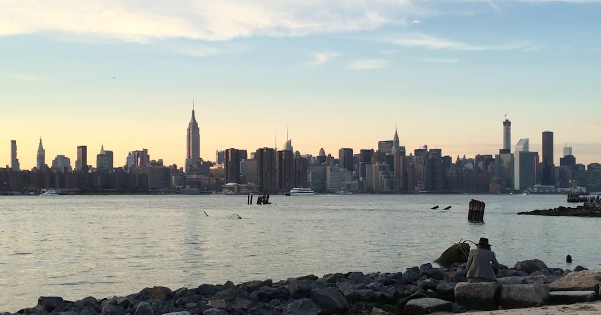 a city skyline behind a body of water