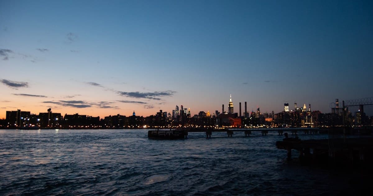 A body of water with a city in the background