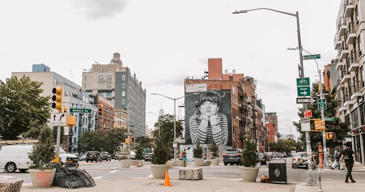 Vibrant street view of Bedford Avenue with famous mural and urban traffic in NYC.