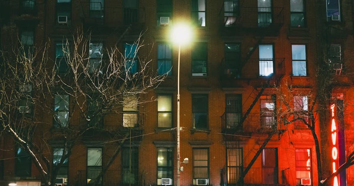 Capture of a dimly lit New York City building facade at night, highlighting urban architecture.