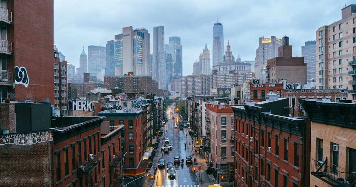 Dynamic view of a rainy New York City street with iconic skyline in the background.
