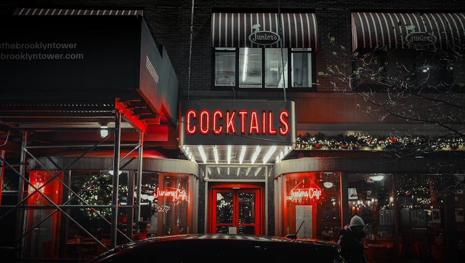 A neon-lit entrance of Juniors Cafe in NYC showcasing a vibrant nightlife scene with festive decorations.