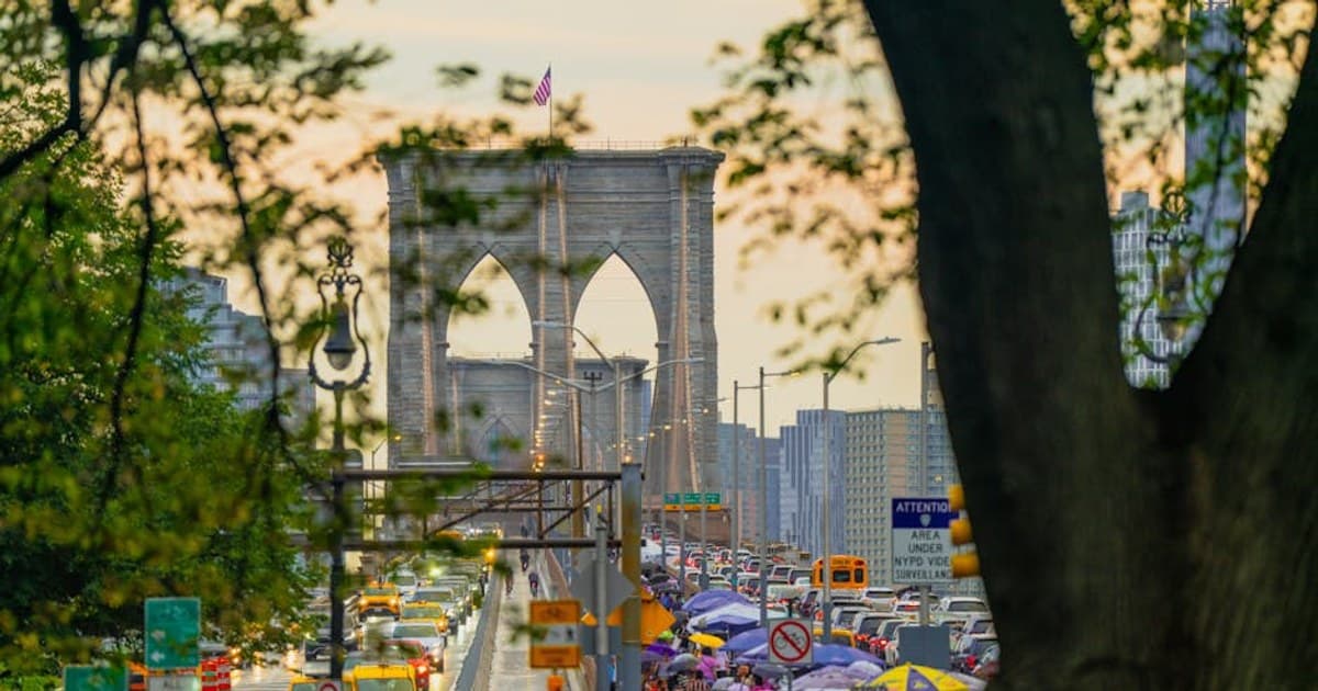 Bustling traffic and pedestrians on a busy day at New York's iconic Brooklyn Bridge.