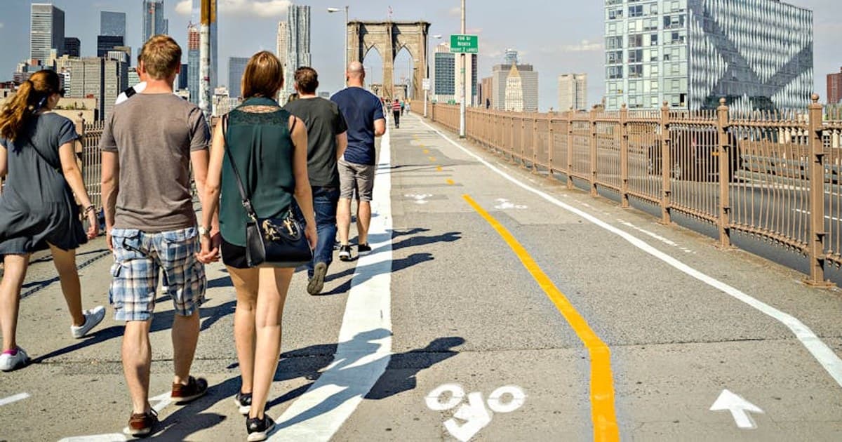 People walking along the pedestrian path on the iconic Brooklyn Bridge in New York City.