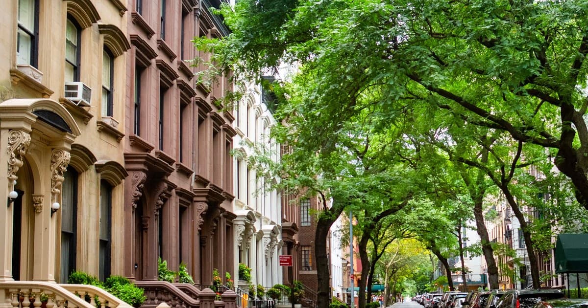 A picturesque view of a tree-lined brownstone street in Brooklyn, New York.