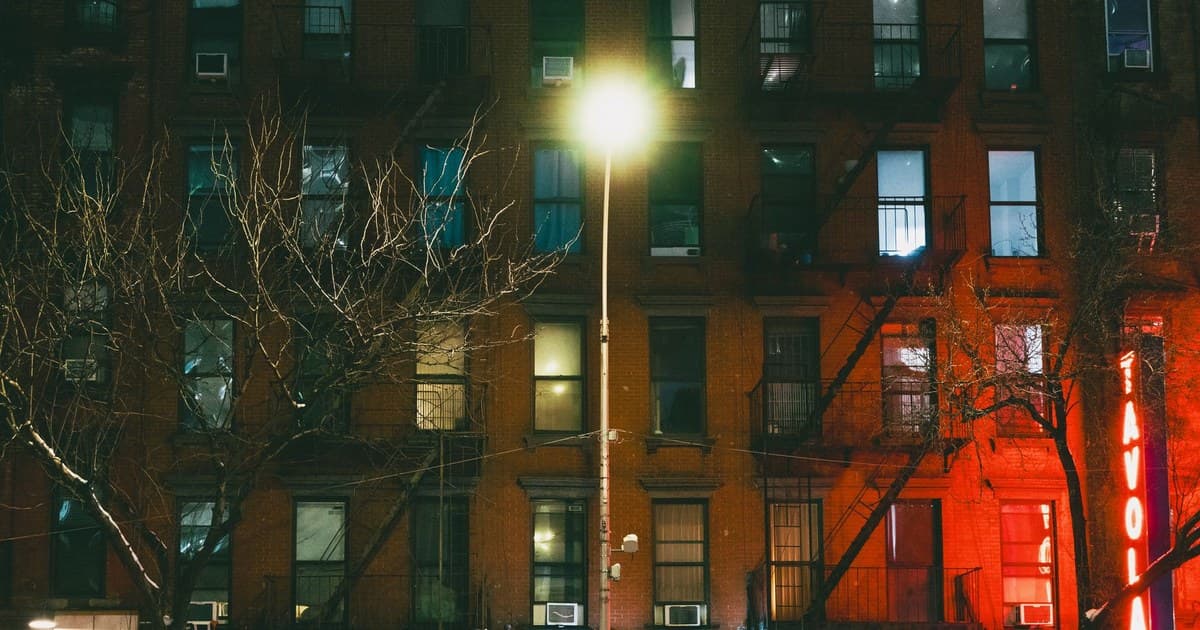 Capture of a dimly lit New York City building facade at night, highlighting urban architecture.