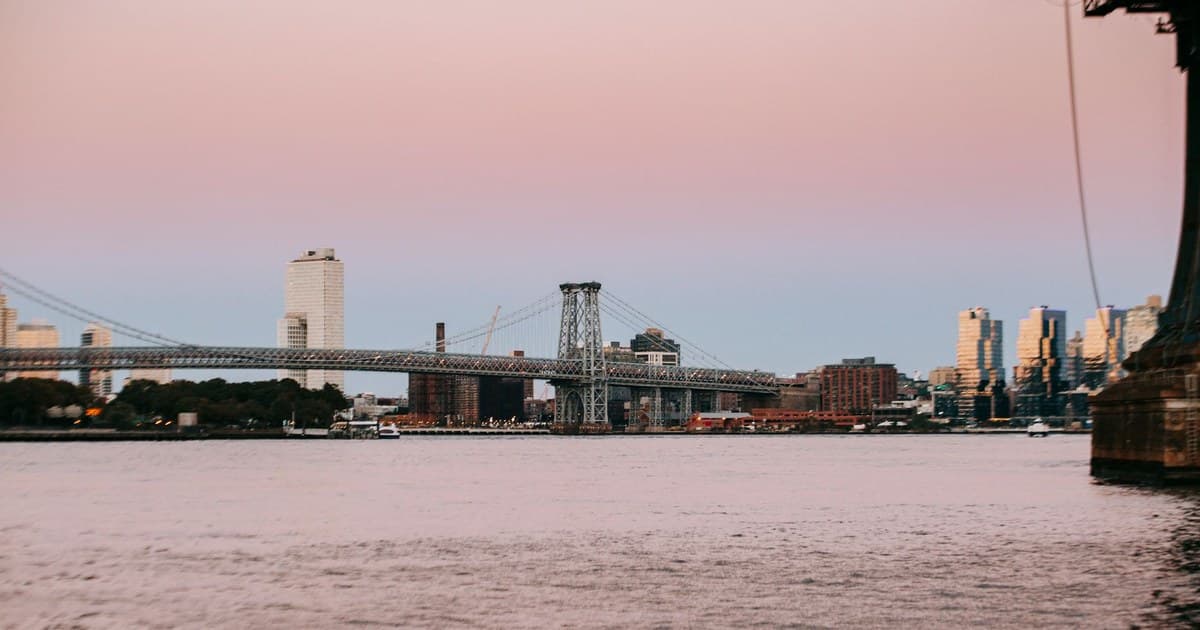 Williamsburg Bridge across East River placed in New York City at sunset